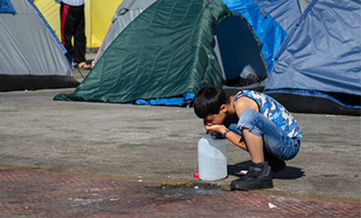 Migrant child drinking water. © Istock